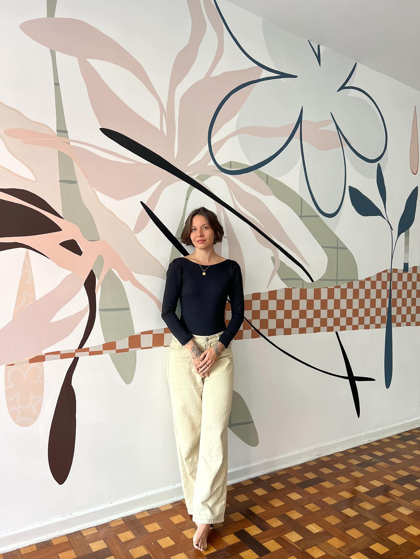 Marcela Amaro diante de uma arte mural criada por ela